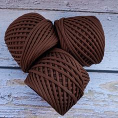 two heart shaped balls of yarn on a wooden surface