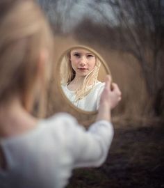 a woman is looking at herself in the mirror