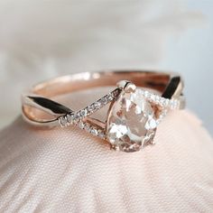 a close up of a ring on top of a white cloth with diamonds around it