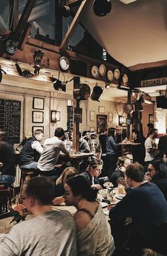 a group of people sitting at tables in a restaurant