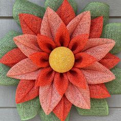 an orange and green flower is hanging on the side of a building with burlocks