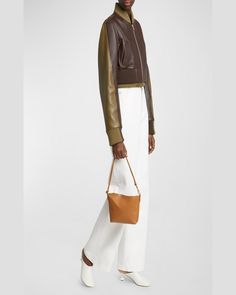 "Find LOEWE Puzzle Fold Leather Pouch Shoulder Bag on Editorialist. The Loewe Puzzle Fold Pouch Shoulder Bag is crafted from leather and features a detachable, adjustable shoulder strap. It can be worn as a clutch or shoulder bag. It has a zip top closure. The bag measures approximately 6\"H x 9\"W x 2.5\"D. It was made in Spain." Leather Handled Shoulder Bag For Evening In Fall, Textured Leather Shoulder Bag For Fall, Soft Leather Clutch Bucket Bag, Modern Soft Leather Bucket Bag For Fall, Fall Evening Shoulder Bag With Leather Handles, Leather Bucket Bag With Detachable Strap For Fall, Fall Leather Bucket Bag With Detachable Strap, Leather Clutch Bag For Fall, Luxury Bucket Bag With Removable Pouch For Fall