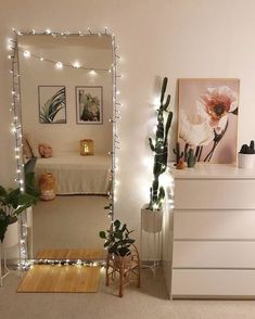 a bedroom decorated with lights and potted plants on the dresser next to a bed