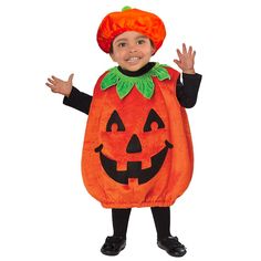 a little boy dressed up in a pumpkin costume for halloween with his hands out to the side