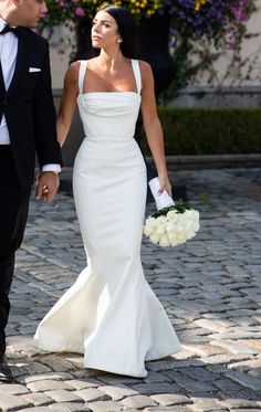 a bride and groom walking down the street