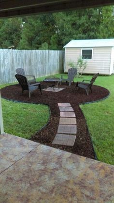 a backyard with lawn chairs and a fire pit