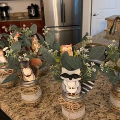 three mason jars filled with flowers and stuffed animals