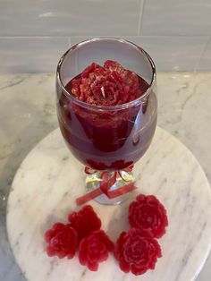 a glass filled with raspberries on top of a marble table