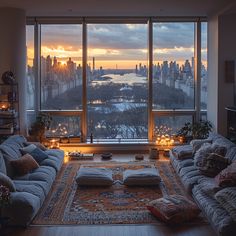 a living room filled with furniture and a large window overlooking the city at night time