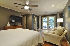 a bedroom with a bed, chair and television