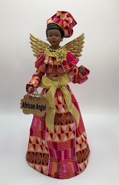 an african angel figurine holding a sign that says african angel on it's chest