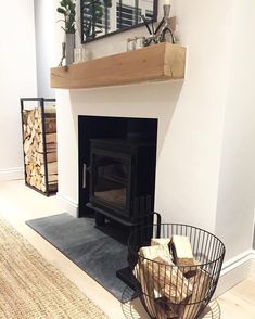 a fire place in a living room with a basket on the floor next to it