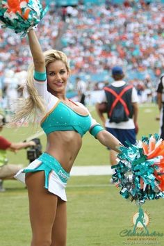 a cheerleader is dancing on the field with her pom poms in hand