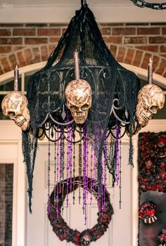 a black chandelier with skulls hanging from it's sides and purple beads