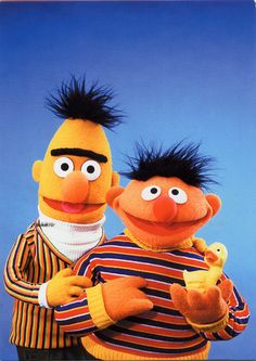 two sesame street characters standing next to each other