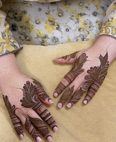 two hands with henna designs on them