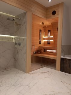 a bathroom with marble counter tops and wooden walls, along with a walk in shower