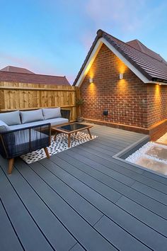 a patio with couches and lights on the side of it next to a brick building