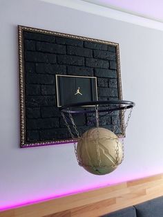 a basketball hanging on the wall next to a basket with a ball attached to it