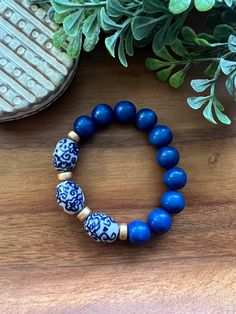 Such gorgeous shades of royal blue wood beads paired with floral blue and white ceramic chinoiserie beads.  Bracelet measures appropriately 7.5 or 8 inches. Message me if you need a different size! Thanks so much for stopping by Beaded Blues! Blue Wooden Beads Stretch Bracelet As Gift, Blue Wooden Beaded Bracelets As Gift, Traditional Blue Beaded Bracelets With Large Beads, Adjustable Blue Stretch Bracelet With Wooden Beads, Unique Blue Bracelets With Large Beads, Blue Stretch Bracelet With Round Wooden Beads, Traditional Hand-strung Blue Beaded Bracelets, Blue Wooden Beads Stretch Bracelet, Hand-strung Blue Beaded Bracelets With Round Beads