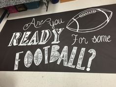 a sign that says are you ready for some football? on the floor in a classroom