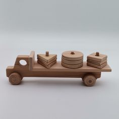 a wooden toy truck with four pieces of wood on the back