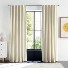 a living room with white walls and curtains