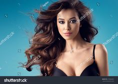 a beautiful woman with long hair posing for the camera, wearing a black bra top