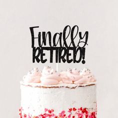 a white cake with pink frosting and black lettering that says finally retired on top