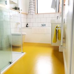 a bathroom with yellow flooring and white walls