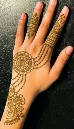 a woman's hand with henna tattoos on it