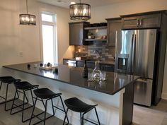 a modern kitchen with stainless steel appliances and bar stools