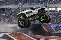 a monster truck is in mid air over a track