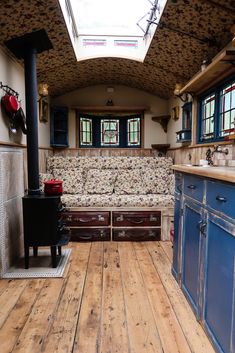 an old fashioned kitchen with blue cabinets and wood flooring is seen in this image