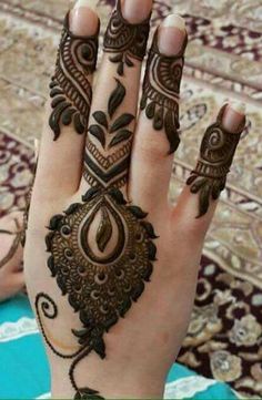 a woman's hand with henna tattoos on it