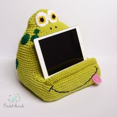 a stuffed frog holding a computer screen in its mouth