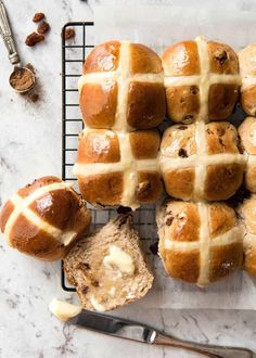 hot cross buns on a cooling rack with butter