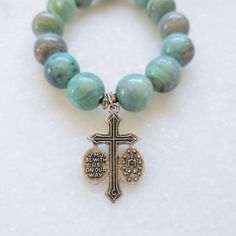 These exquisite beads truly encapsulate the beauty of the emerald coast. Each turquoise bead is naturally unique resulting in a stunning array of tranquil aqua colors. The bracelet is expertly strung on a durable elastic band for the perfect fit that complements any look. The Bracelet features a Jesus/Mary/Joseph vintage crucifix silver medal with "JMJ Be With Us On Our Way" on the back. Spiritual Turquoise Round Stretch Bracelet, Amazonite Gemstone Beads Stretch Bracelet, Turquoise Spiritual Stretch Bracelet With 8mm Beads, Spiritual Turquoise Stretch Bracelet With 8mm Beads, Turquoise Amazonite Bracelet With 8mm Beads, Turquoise Rosary Bracelet With Round Beads, Turquoise Spiritual Rosary Bracelet With Round Beads, Spiritual Turquoise Rosary Bracelet With Round Beads, Spiritual Stretch Bracelet With Amazonite Beads