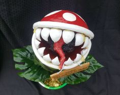 a fake mushroom with teeth and fangs on it's head is sitting on top of a plant