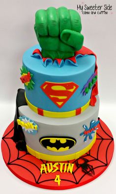 a birthday cake with a batman and spider - man theme on the top, made to look like a fist