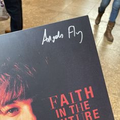 a person holding up a book with the title faith in the future written on it