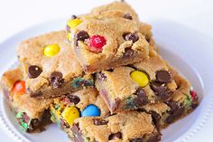 a white plate topped with chocolate chip cookies and m & m candy bar bars on top of each other