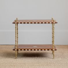 two tiered wooden shelf with gold trimmings on the bottom and white dots