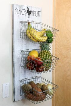 two metal baskets filled with fruit hanging on a wall