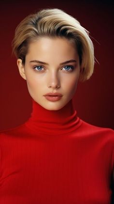 a woman with blonde hair and blue eyes wearing a red top is looking at the camera