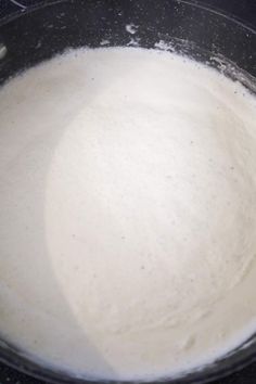 a pan filled with white liquid on top of a stove