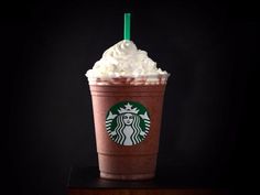 a starbucks drink with whipped cream and a green straw