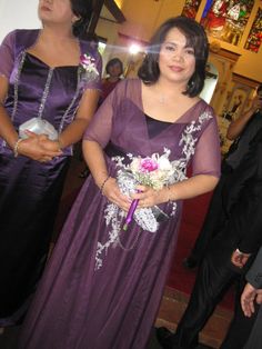 two women in purple dresses standing next to each other