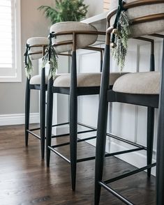 three bar stools with christmas garland on them