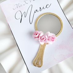 a pink flower brooch sitting on top of a card